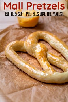 some pretzels are laying on top of brown wax paper next to oranges