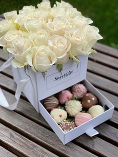 a box filled with white roses and chocolates