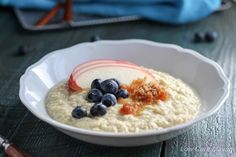 a bowl of oatmeal with blueberries, apples and cinnamon on top