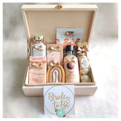 an open gift box filled with personal care items on a white surface and a sign that says bridal to be