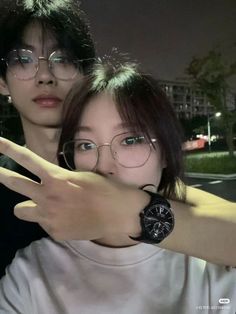 two people are posing for the camera with their arms around each other while wearing glasses