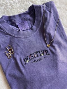 POSITIVE VIBES ONLY! super trendy embroidered tshirt! pair it with your favorite denim shorts or leggings. floral design with self love quote 💜 get summertime fine with a pop of color!  This T-Shirt is available in 5 colors: Ash Gray, Grape Purple, Emerald, Wine, and Carribean Blue. If there is a color you have in mind other than the ones available, send me a message and I can help! -Sweatshirt brand: Comfort Colors -Sizes available: Adult Small - Adult 2XL -Fit: slightly oversized fit - I'd su Trendy Embroidered Summer T-shirt, Trendy Crew Neck T-shirt With Embroidered Text, Casual Letter Embroidery T-shirt For Streetwear, Trendy Short Sleeve T-shirt With Letter Embroidery, Trendy Crew Neck T-shirt With Letter Embroidery, Embroidered Cotton Tops For Streetwear, Spring Streetwear Tops With Letter Embroidery, Casual Summer T-shirt With Letter Embroidery, Spring Tops With Letter Embroidery For Streetwear