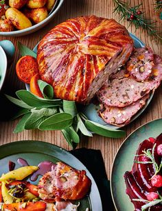 a table topped with plates filled with meat and veggies next to other dishes