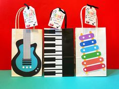 three shopping bags decorated with musical instruments and thank you for the music teacher's day