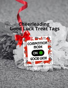 a close up of a tag on a pile of shredded paper with text reading, cheerleading good luck treat tags