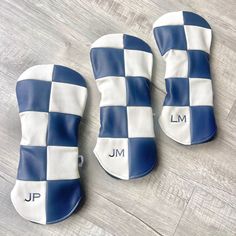 three blue and white checkered oven mitts with the initials jm on them