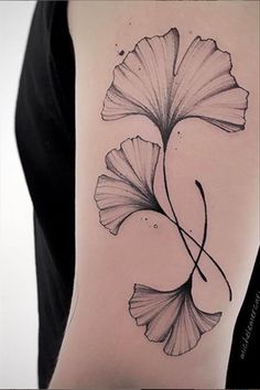 a black and white photo of a flower on the back of a woman's arm