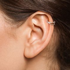 a close up of a person's ear with a single piece of jewelry on it