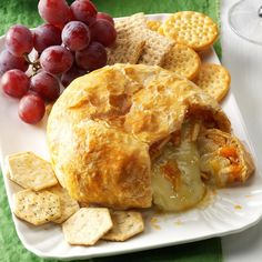 some grapes and crackers on a white plate