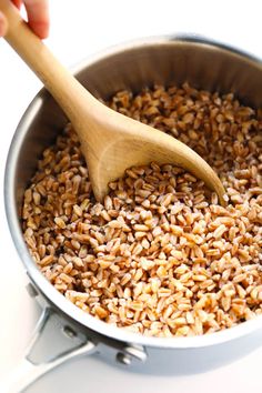 a wooden spoon in a pot full of brown rice