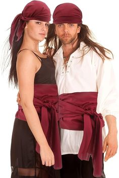 a man and woman dressed in pirate garb standing next to each other with their arms around each other