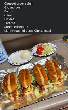 three hot dogs sitting on top of tin foil next to a plate with condiments