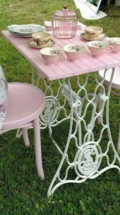 a pink table and chairs in the grass