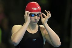 a woman wearing a red swimming cap and goggles