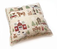 a pillow with a farm scene on the front and side, sitting on top of a white surface