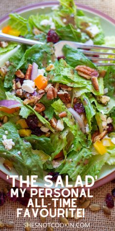 a salad with lettuce, cranberries and pecans on the side