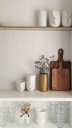 the shelves are filled with dishes, cups and utensils on top of them