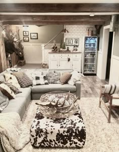 a living room filled with furniture and a cow print rug on top of a wooden floor