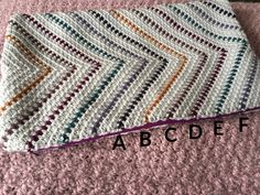 a crocheted blanket with the words abcdef written in front of it