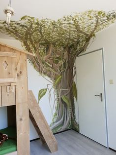 a room with a tree painted on the wall and stairs leading up to an open door