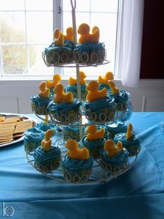 cupcakes are arranged in the shape of train tracks on a table with blue cloth