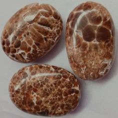 three brown stones sitting on top of a white surface