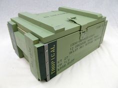 an old green box sitting on top of a white sheet