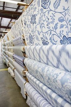 several rows of mattresses lined up in a warehouse with blue and white floral designs on them