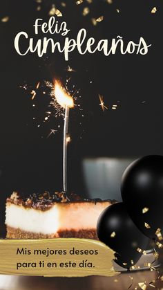 a piece of cake with a lit candle on it and some black balloons in the background