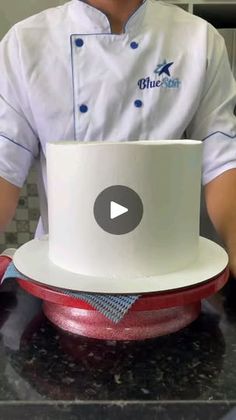 a chef is decorating a white hat with red piping on the front and blue piping on the back