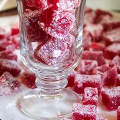 some sugar cubes are in a glass on a table with other pieces of food