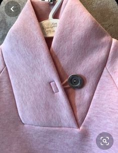 a pink shirt with a button on the collar