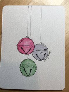 three balls hanging from strings with faces drawn on them in watercolor and pencils