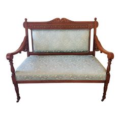 an antique wooden bench with upholstered fabric