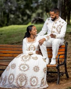 a man and woman sitting on top of a wooden bench