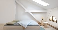 an attic bedroom with white walls and wood flooring, along with a bed that has two pillows on it