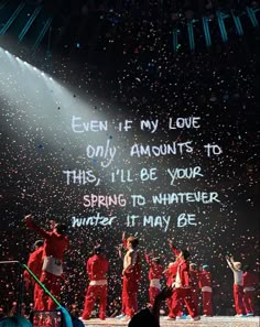 a group of people standing on top of a stage with confetti in the air