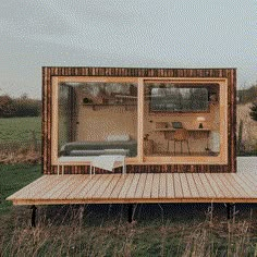 a small wooden house sitting on top of a grass covered field