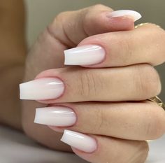 a woman's hand with white nail polish on it