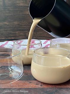 a pitcher pouring batter into glasses on top of a wooden table