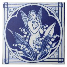 a blue and white tile with an angel surrounded by lily - of - the - valley flowers