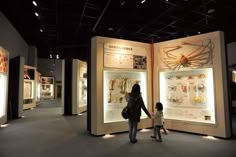 a woman and child standing in front of an exhibit