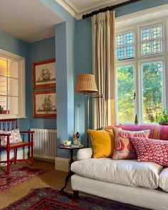 a living room filled with lots of furniture and pillows on top of a white couch