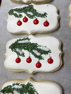 christmas cookies decorated with white icing and red balls on top of each cookie sheet