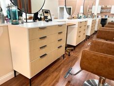 a hair salon with chairs, mirrors and other items on the counter top in front of it