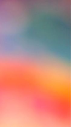 the blurry image shows an orange, pink and blue sky with clouds in the background