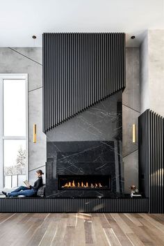 a woman sitting on the floor in front of a fire place with her feet up