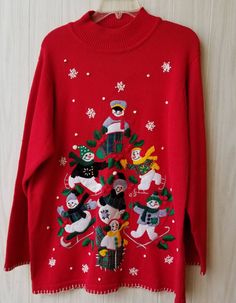 a red sweater with cats and snowmen on it