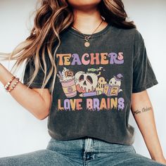 Get ready to be OBSESSED with your new Teachers Love Brains shirt. It's the cutest and most trendy way to emit all those Halloween Teacher vibes! This is the perfect retro Halloween t-shirt for your favorite Teacher! Crafted from the softest fabric, this Comfort Colors tee ensures the utmost comfort throughout the day. * Q U I C K F A C T S * ✺ 100% preshrunk cotton ✺ Wash and dry on delicate, inside out (on cool for best results) * S I Z I N G * ✺ Models are wearing size Large ✺ Sizing is unise Fall Teacher Shirts Funny, Skull Shirts For Teachers, Halloween Parfait, Teacher Vibes, Favorite Teacher, Ghost Shirt, Teacher Tees, Comfort Colors Shirt, Comfort Colors Tee