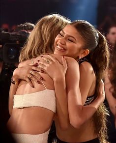 two women hugging each other on stage